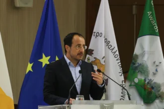 Ο Πρόεδρος της Κυπριακής Δημοκρατίας Νίκος Χριστοδουλίδης μιλά σε βήμα με τις σημαίες της Κύπρου και της Ευρωπαϊκής Ένωσης