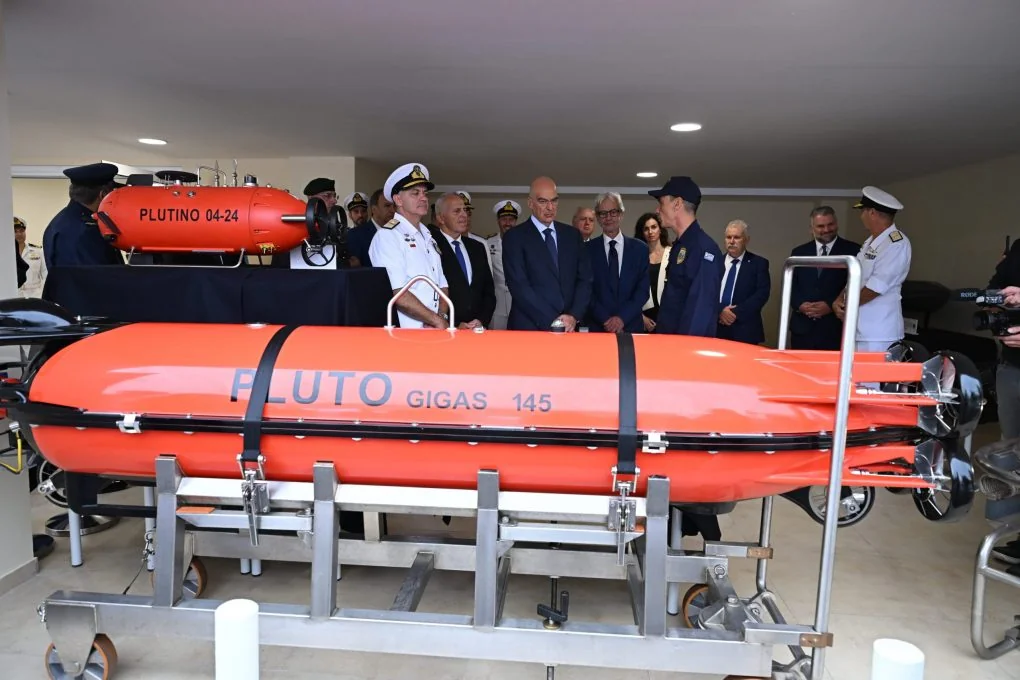Ο Νίκος Δένδιας και αξιωματικοί πίσω από πορτοκαλί υποβρύχιο όχημα PLUTO GIGAS, με το PLUTINO στο βάθος