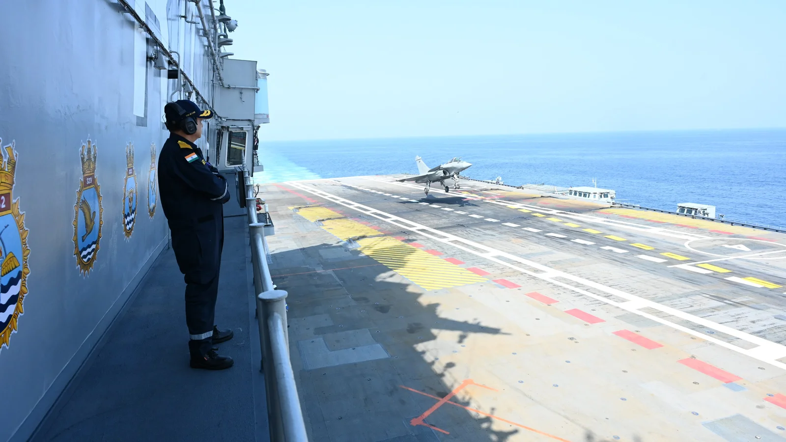 Μαχητικό Rafale Marine στο κατάστρωμα πτήσης του INS Vikrant, με αξιωματικό του ινδικού Ναυτικού να παρακολουθεί από τον πύργο