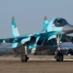 Γκρι ρωσικό μαχητικό-βομβαρδιστικό Su-34 με τον αριθμό 01 στον διάδρομο αεροδρομίου
