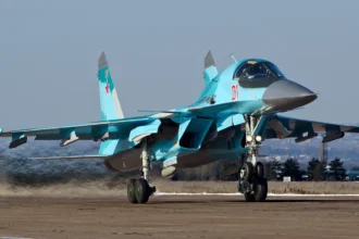 Γκρι ρωσικό μαχητικό-βομβαρδιστικό Su-34 με τον αριθμό 01 στον διάδρομο αεροδρομίου