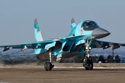 Γκρι ρωσικό μαχητικό-βομβαρδιστικό Su-34 με τον αριθμό 01 στον διάδρομο αεροδρομίου