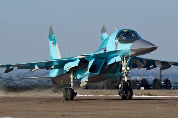 Γκρι ρωσικό μαχητικό-βομβαρδιστικό Su-34 με τον αριθμό 01 στον διάδρομο αεροδρομίου