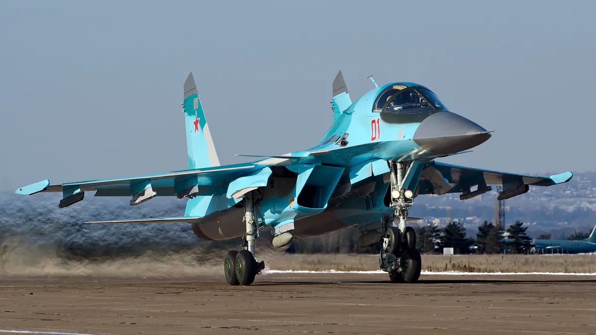 Γκρι ρωσικό μαχητικό-βομβαρδιστικό Su-34 με τον αριθμό 01 στον διάδρομο αεροδρομίου