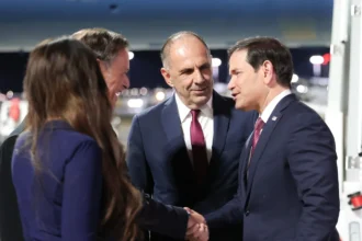 Ο Μάρκο Ρούμπιο ανταλλάσσει χειραψία κατά την υποδοχή του από τον Γιώργο Γεραπετρίτη στο αεροδρόμιο της Αθήνας, δίπλα στη σκάλα του αεροσκάφους, τη νύχτα