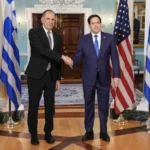 Ο Γιώργος Γεραπετρίτης και ο Μάρκο Ρούμπιο ανταλλάσσουν χειραψία μπροστά σε ελληνικές και αμερικανικές σημαίες στο Στέιτ Ντιπάρτμεντ