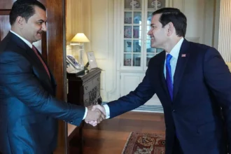 Ο Σαντάμ Χαφτάρ σφίγγει το χέρι του Αμερικανού υπουργού Εξωτερικών Μάρκο Ρούμπιο σε γραφείο με ξύλινη πόρτα και βιτρίνα