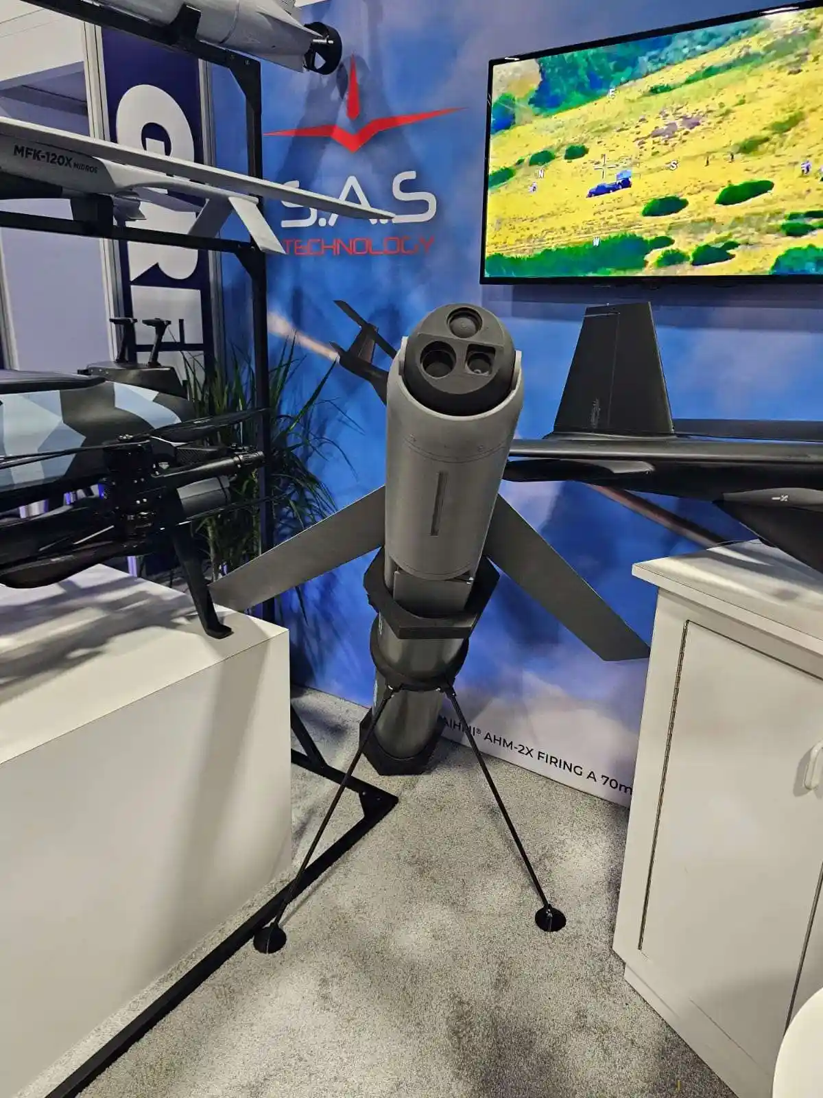 Το φορητό loitering munition Spearhead σε τρίποδο, με οπτικοηλεκτρονική κεφαλή τριών ανοιγμάτων και πτερύγια, στο περίπτερο της SAS Technology