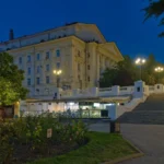 Το Δραματικό Θέατρο Λουνατσάρσκι στη Σεβαστούπολη το σούρουπο, με φωτισμένους δρόμους