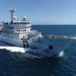 Λευκό περιπολικό της Ακτοφυλακής της Ταϊβάν με τον αριθμό CG1002 και κόκκινη και μπλε λωρίδα στην πλώρη πλέει με ταχύτητα στην ανοιχτή θάλασσα
