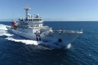 Λευκό περιπολικό της Ακτοφυλακής της Ταϊβάν με τον αριθμό CG1002 και κόκκινη και μπλε λωρίδα στην πλώρη πλέει με ταχύτητα στην ανοιχτή θάλασσα