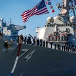 Το αμερικανικό αντιτορπιλικό USS McFaul (DDG 74) με τον αριθμό 74 στην πλώρη και το πλήρωμα παραταγμένο στο κατάστρωμα, κατά την επιστροφή στο Νόρφολκ
