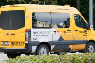 Κοινωνικό ταξί με τα χρώματα της Yandex Go σε δρόμο της Μόσχας