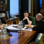 Ο Βολοντίμιρ Ζελένσκι και συνεργάτες του κάθονται σε μακρύ τραπέζι με έγγραφα κατά τη διάρκεια συνομιλίας