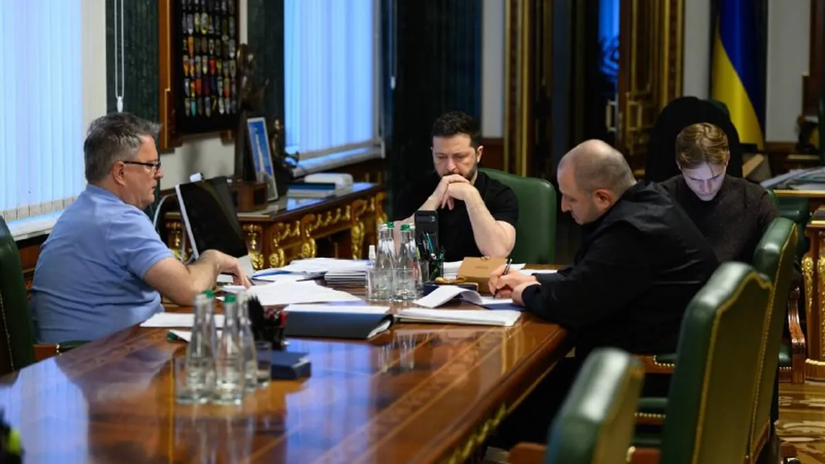 Ο Βολοντίμιρ Ζελένσκι και συνεργάτες του κάθονται σε μακρύ τραπέζι με έγγραφα κατά τη διάρκεια συνομιλίας