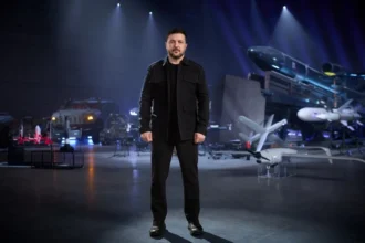 Ο Ουκρανός πρόεδρος Βολοντίμιρ Ζελένσκι όρθιος σε αίθουσα με ουκρανικής κατασκευής πυραύλους, drones και οχήματα